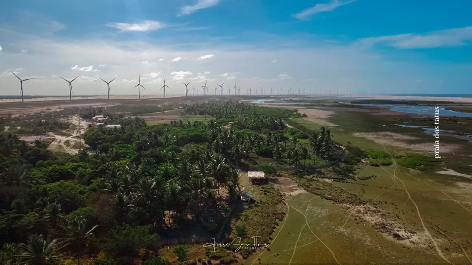 Paisagem entre dunas, rio e parque eólico